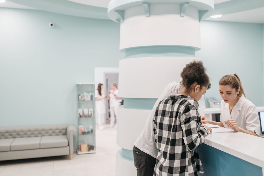 healthcare professionals assisting at a modern clinic reception desk.