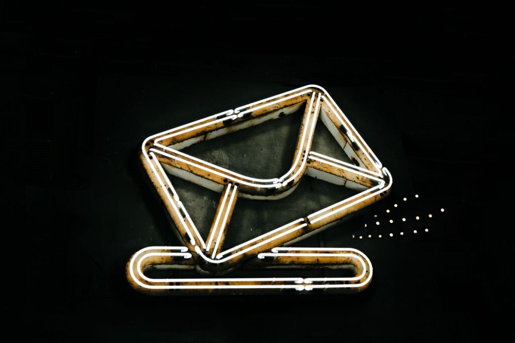 a glowing neon envelope symbol against a black background, conveying messaging or email concept.